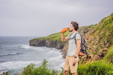 Güzel kayaların ve denizin arka planında erkek turist. Yürüyüş konsepti. Tobizin pelerini. Vladivostok, Russky adası. Japon Denizi. Primorye. Primorsky krai. Rusya 'nın doğası. Turizm ve seyahat