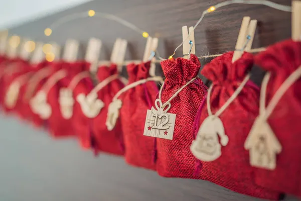 Calendario de Adviento bolsas rojas en una cuerda cuelgan de una cama infantil — Foto de Stock