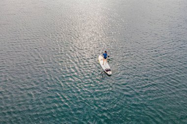 Denizde Dik Yüzen Genç Kadınlar Eğleniyor. - Süper. Kızıl saçlı kız kayaların yanındaki sörf tahtasında çalışıyor.