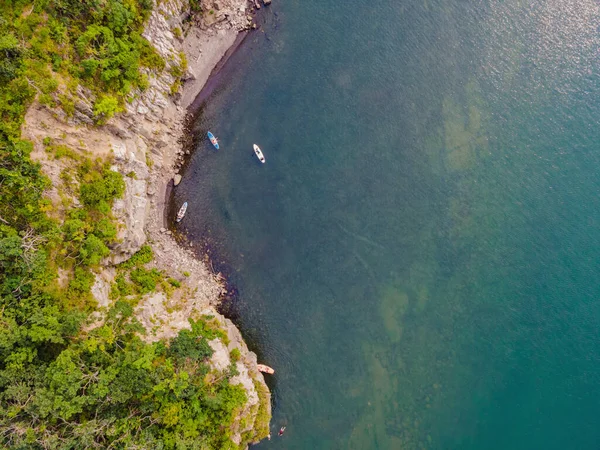 Jovens mulheres se divertindo Stand Up Paddling no mar. SUP. Menina de cabelo vermelho Treinamento em Paddle Board perto das rochas — Fotografia de Stock