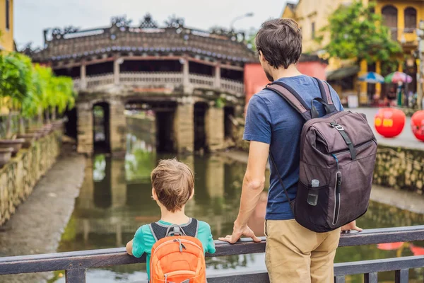 Otec a syn turisté na pozadí Krásný japonský most v Hoi An. Vietnam. Vietnam se opět otevírá turistům po karanténě Coronovirus COVID 19 — Stock fotografie