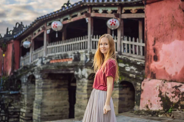 ホイアンの美しい日本の橋を背景にした女性観光客。ベトナム。ベトナムは検疫後に再び観光客に開きます｜Coronvirus COVID 19 — ストック写真