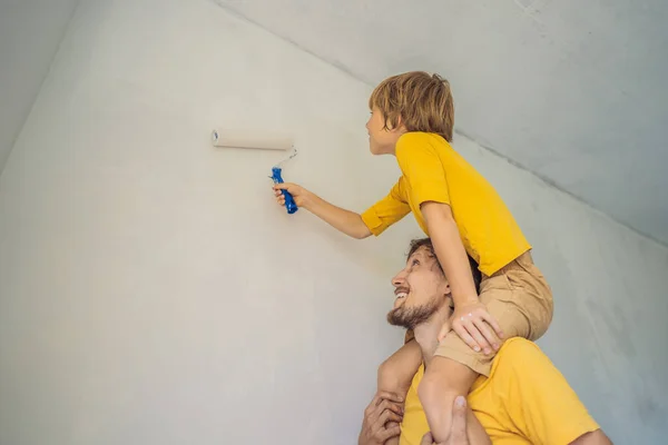 Baba ve oğul evlerinde duvar boyuyor. Taşınırken yapıyorlar. — Stok fotoğraf