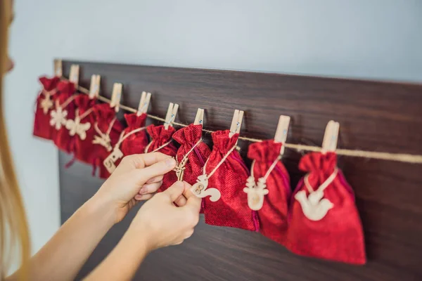 Woman making Christmas advent calendar. Pouches on a rope — Stock Photo, Image