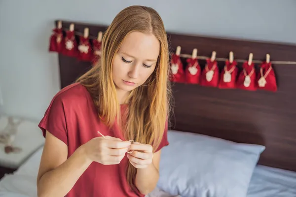 Женщина делает рождественский календарь. Сумки на веревке — стоковое фото