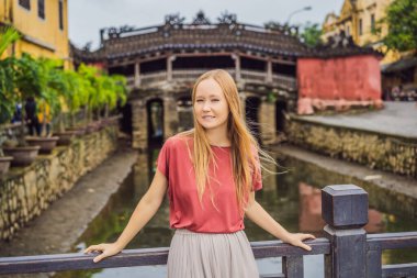 Hoi An 'daki Güzel Japon Köprüsü' nün arka planındaki kadın turist. Vietnam. Vietnam, Coronovirus COVID 19 karantinasından sonra turistlere tekrar açıldı