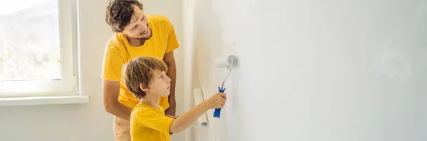 Vader en zoon schilderen een muur in hun huis doen het in de loop van het verhuizen in BANNER, LANG FORMAT — Stockfoto