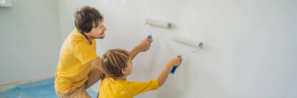 Ojciec i syn malujący ścianę w ich domu robią to w trakcie przeprowadzki do BANNER, LONG FORMAT — Zdjęcie stockowe