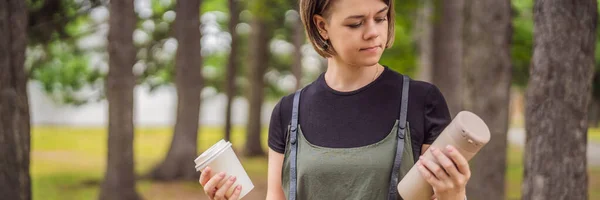 BANNER, FORMATO LARGO Retrato de la joven feliz sonriente comparando la taza termo o vaso con la taza de café de papel desechable —  Fotos de Stock