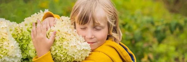 庭でピンクの花を楽しむ男の子｜バナー、ロングフォーマット — ストック写真