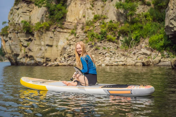 Jeunes femmes qui s'amusent Levez-vous pagayer dans la mer. SUP. Fille aux cheveux roux Formation sur Paddle Board près des rochers — Photo