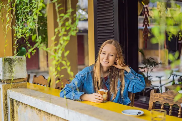 Портрет молодої красивої жінки, що сидить у кафе на відкритому повітрі, п'є каву — стокове фото