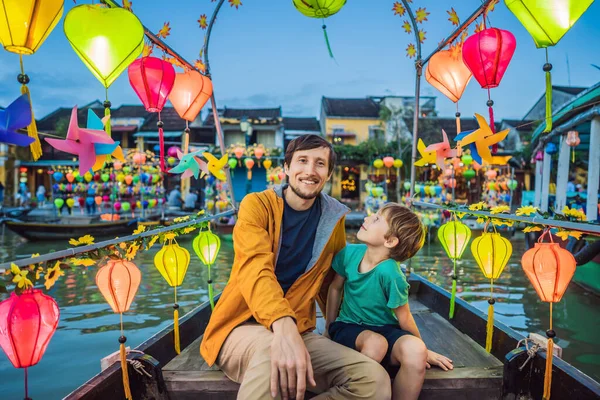 Feliz padre de familia y el hijo de los viajeros montar un barco nacional en el fondo de Hoi Una antigua ciudad, Vietnam. Vietnam se abre de nuevo a los turistas después de la cuarentena Coronovirus COVID 19 —  Fotos de Stock