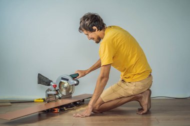 Adam sıcak film katta yeni ahşap Laminat parke yükleme. Kızılötesi yerden ısıtma sistemi Laminat zemin altında