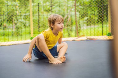 mutlu çocuk açık havada bahçe trambolin üzerinde gökyüzünde yüksek atlama çalış.