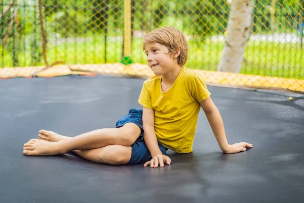 快乐的小男孩在花园里蹦床上跳跃在高空户外扮演 — 图库照片