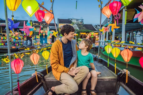 Šťastný rodinný otec a syn cestovatelů jezdit na národní lodi na pozadí Hoi An starobylé město, Vietnam. Vietnam se opět otevírá turistům po karanténě Coronovirus COVID 19 — Stock fotografie