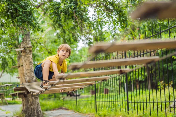 Little boy in a rope park. Active physical recreation of the child in the fresh air in the park. Training for children — Stock Photo, Image