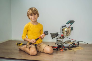 Çocuk, sıcak bir film zeminine yeni ahşap kaplama döşeme yaptırıyor. Kızıl ötesi ısıtma sistemi lamine zemin altında