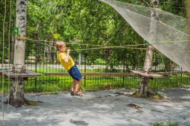 Halat parkında küçük bir çocuk. Parkta temiz havada çocuğun aktif fiziksel rekreasyon. Çocuklar için eğitim