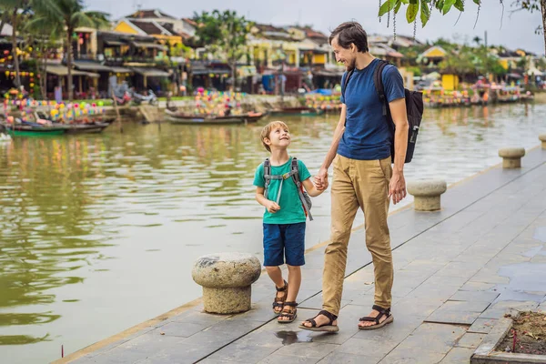 Apa és fia utazók a háttérben Hoi An ősi város, Vietnam. Vietnam újra megnyitja kapuit a turisták után karantén Coronovírus COVID 19 — Stock Fotó
