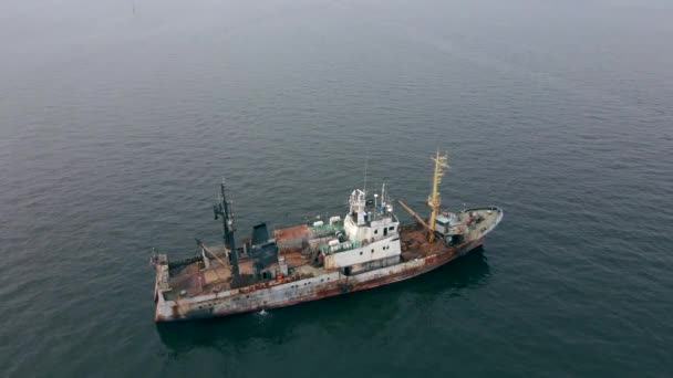 Un disparo aéreo. Un viejo barco oxidado en el mar. Reducir las emisiones de carbono. Concepto de emisiones de buques viejos e ineficientes. Un barco que necesita ser reciclado — Vídeos de Stock