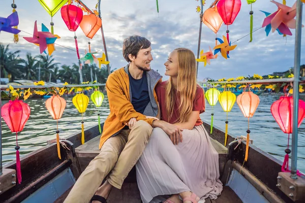 Glada par resenärer rida en nationell båt på bakgrund av Hoi An antika staden, Vietnam. Vietnam öppnar för turister igen efter karantän Coronovirus COVID 19 — Stockfoto