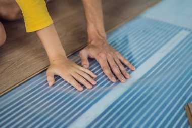 Ahşap zemin, sıcak bir film zeminine kaplanmış. Evdeki rahatlık. Sıcak zemin konsepti. Evde ve dairede ısıtma var.