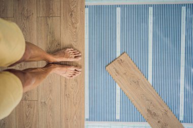 Ahşap zemin, sıcak bir film zeminine kaplanmış. Evdeki rahatlık. Sıcak zemin konsepti. Evde ve dairede ısıtma var.