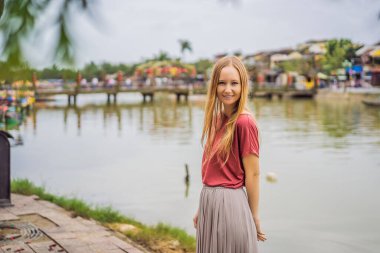 Hoi 'nin arka planındaki kadın turist. Vietnam' ın antik bir kasabası. Vietnam, Coronovirus COVID 19 karantinasından sonra turistlere tekrar açıldı