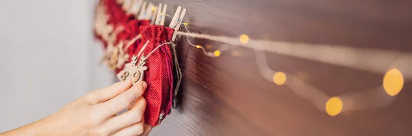 Woman making Christmas advent calendar. Pouches on a rope BANNER, LONG FORMAT — Stock Photo, Image