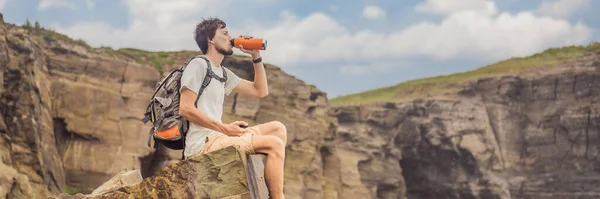 BANNER, LONG FORMAT Male tourist on the background of beautiful rocks and the sea. Hiking concept. Tobizin cape. Vladivostok, island Russky. Sea of Japan. Primorye. Primorsky krai. Nature of Russia