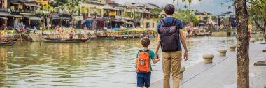 BANNER, LONG eski baba ve oğlu Hoi An antik kasaba, Vietnam 'ın arka planında gezginler. Vietnam, Coronovirus COVID 19 karantinasından sonra turistlere tekrar açıldı