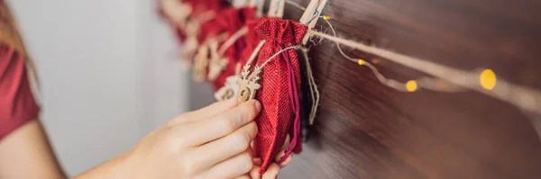 Woman making Christmas advent calendar. Pouches on a rope BANNER, LONG FORMAT — Stock Photo, Image