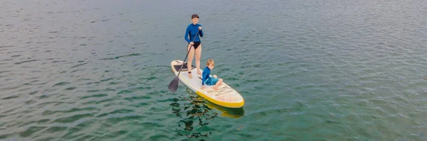 Mère et son fils pagayant debout en pension s'amusant pendant les vacances d'été à la plage BANNER, LONG FORMAT — Photo