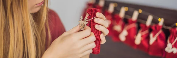 Женщина делает рождественский календарь. Мешки на веревке баннер, длинный Формат — стоковое фото