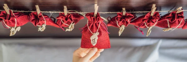 Woman making Christmas advent calendar. Pouches on a rope BANNER, LONG FORMAT — Stock Photo, Image