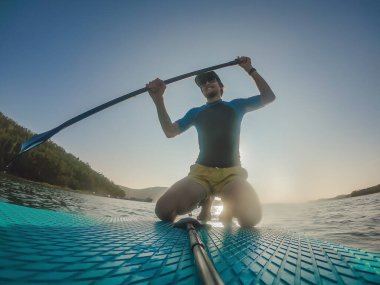 Stand-Up Paddle tahtasındaki çekici adam, SUP
