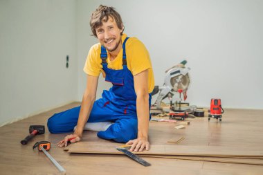 Adam sıcak film katta yeni ahşap Laminat parke yükleme. Kızılötesi yerden ısıtma sistemi Laminat zemin altında