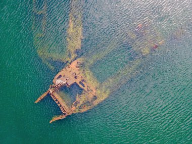Denizden çıkmış terk edilmiş kırık bir gemi enkazı.