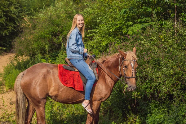 Piękna kobieta ujeżdżająca konia na wsi — Zdjęcie stockowe