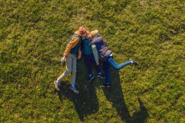 Aile manzarası. Çimlerin üzerinde yatıyordu. Güneşli bir gün. Yeşil doğada birlikte. Hava görüntüleme Drone fotoğrafçılığı