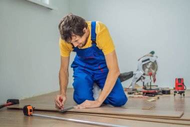 Adam sıcak film katta yeni ahşap Laminat parke yükleme. Kızılötesi yerden ısıtma sistemi Laminat zemin altında