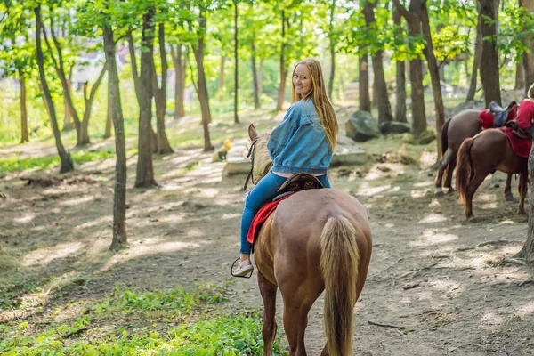 Hermosa mujer montando un caballo en el campo — Foto de Stock
