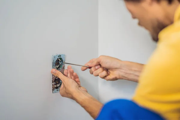 Master elektriker installerar ett uttag i huset — Stockfoto