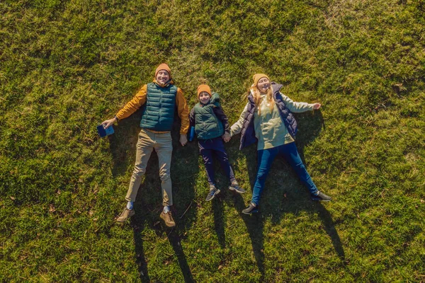 Family top view. lying on the grass. sunny day. in green nature together. Aerial view Drone photography — Stock Photo, Image