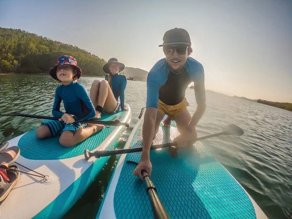 Glückliche dreiköpfige Familie, Vater, Mutter und Sohn, genießen das Stand Up Paddling in den Sommerferien — Stockfoto