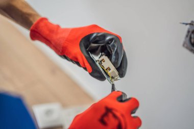 Usta elektrikçi eve bir soket takıyor.