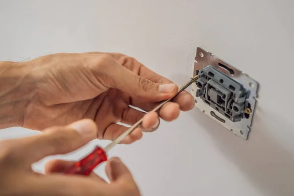Master elektriker installerar ett uttag i huset — Stockfoto