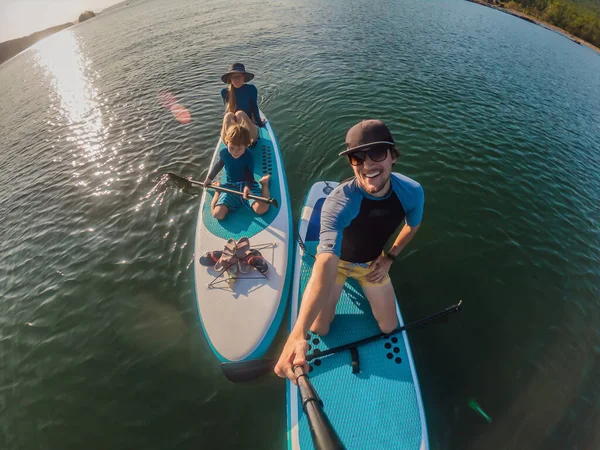 Familia feliz de tres, papá, mamá e hijo, disfrutando de pie remando durante las vacaciones de verano — Foto de Stock